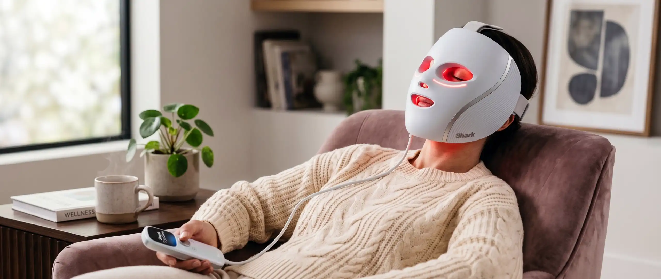 Frau bei der morgendlichen Anwendung der Shark CryoGlow LED-Maske mit rotem Licht